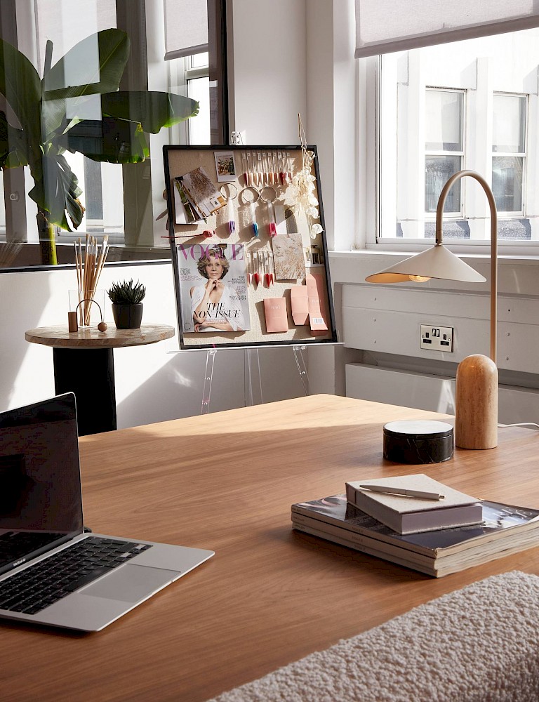 Beauty brand office interior design Brighton — light-filled studio desk with mood board display, arc lamp and timber worktop by Hestia & Hearth